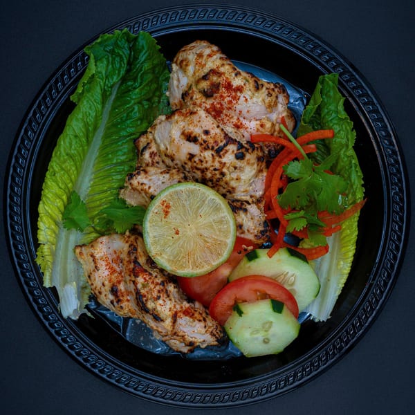 Bittoo's Tikka grilled chicken pieces with lime, lettuce, tomatoes, cucumbers, and red peppers.
